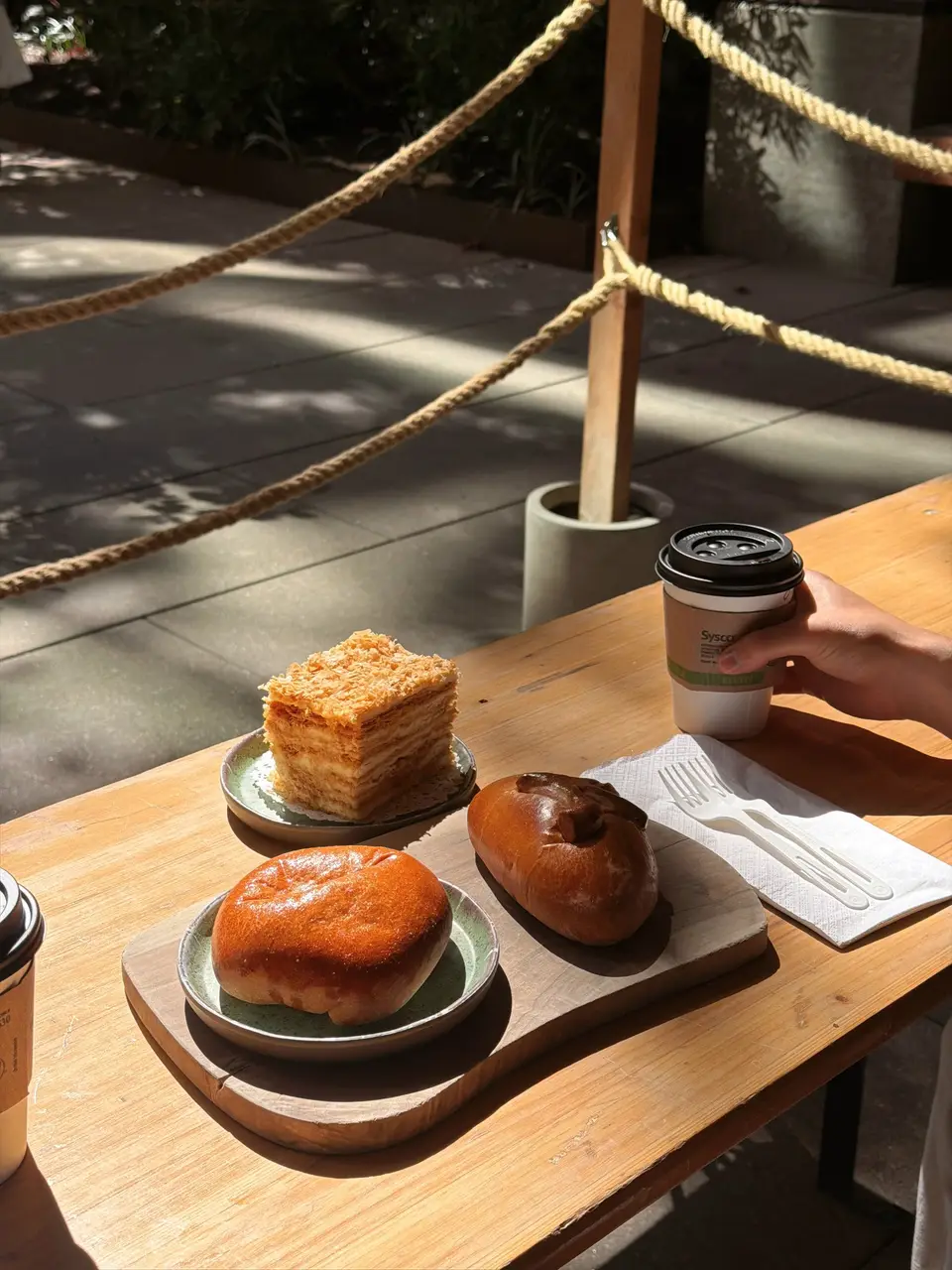 Pastries and coffee on a sunlit outdoor table
