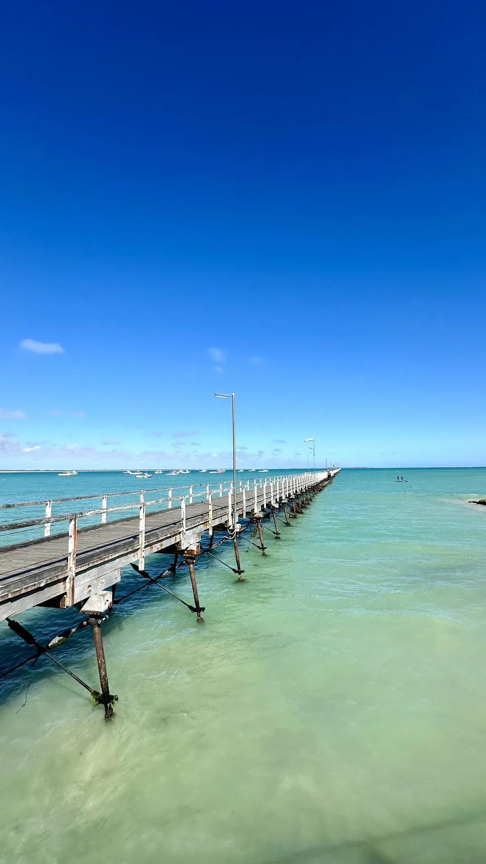 A long pier running out into clear water