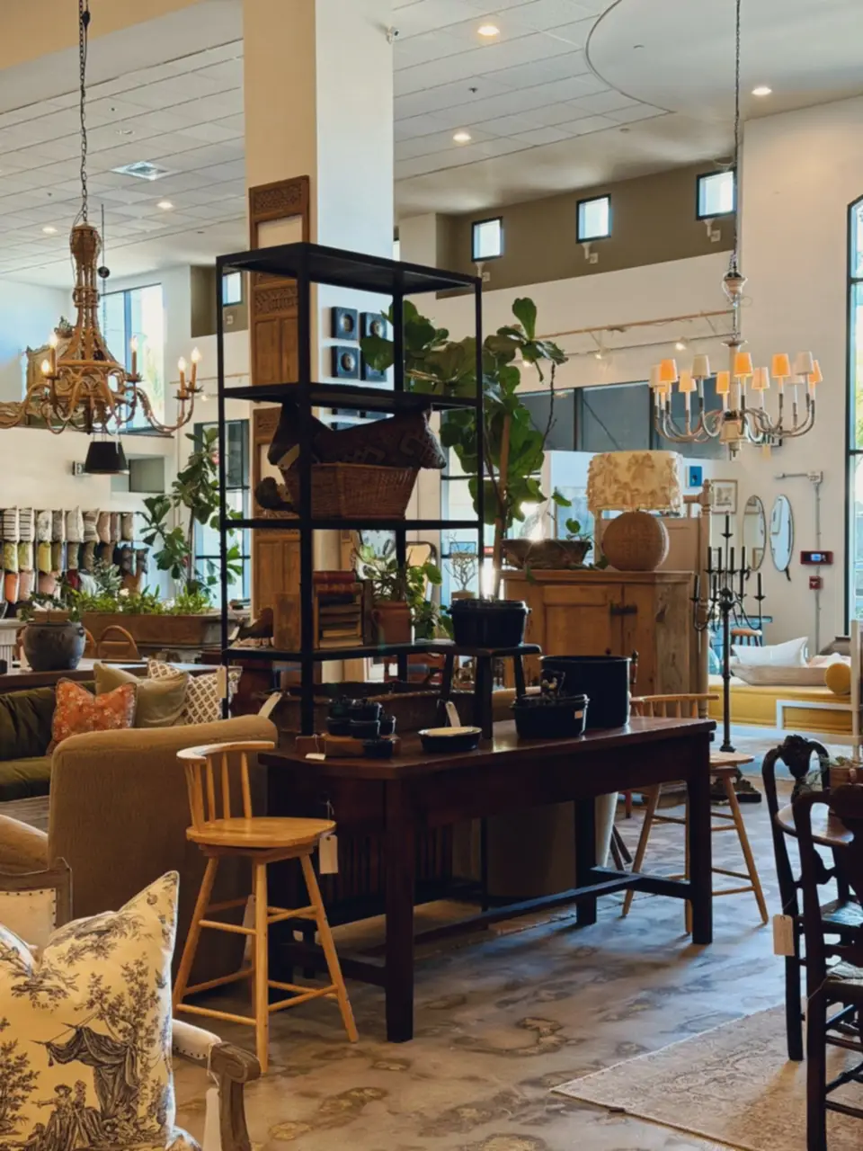 A reading corner of a bright shop with lamps and chairs